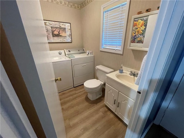 622 Brockinton Pt, Saint Simons Island, GA 31522 - half bath featuring independent washer and dryer, wood finished floors, toilet, vanity, and wallpapered walls
