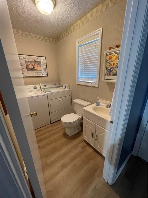 622 Brockinton Pt, Saint Simons Island, GA 31522 - bathroom featuring washer and dryer, wood finished floors, a textured ceiling, vanity, and toilet