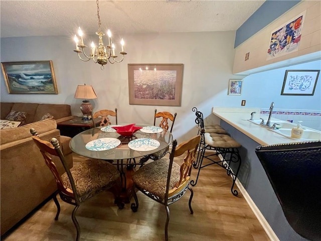 622 Brockinton Pt, Saint Simons Island, GA 31522 - dining room with wood finished floors, a textured ceiling, a chandelier, and baseboards
