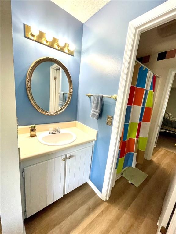 622 Brockinton Pt, Saint Simons Island, GA 31522 - full bath with wood finished floors, vanity, and a shower with shower curtain