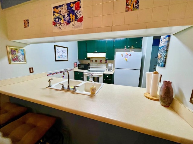 622 Brockinton Pt, Saint Simons Island, GA 31522 - kitchen with white appliances, under cabinet range hood, a sink, green cabinetry, and a peninsula