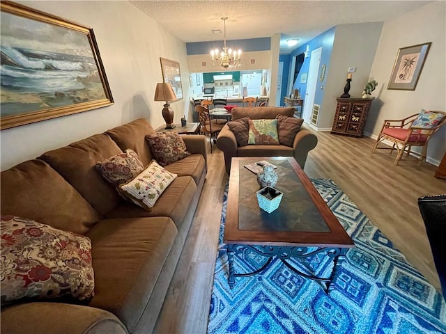 622 Brockinton Pt, Saint Simons Island, GA 31522 - living area featuring a chandelier, wood finished floors, a textured ceiling, and baseboards