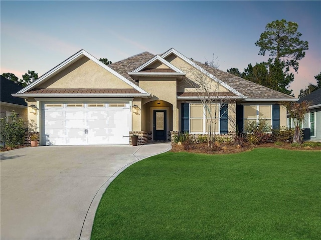 view of front of property with a yard and a garage