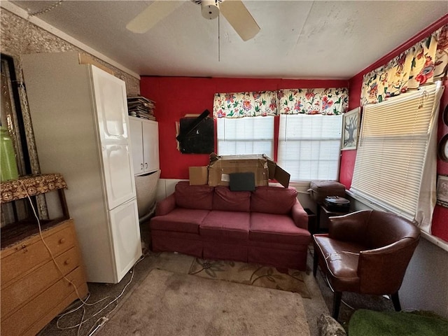 carpeted living room with ceiling fan