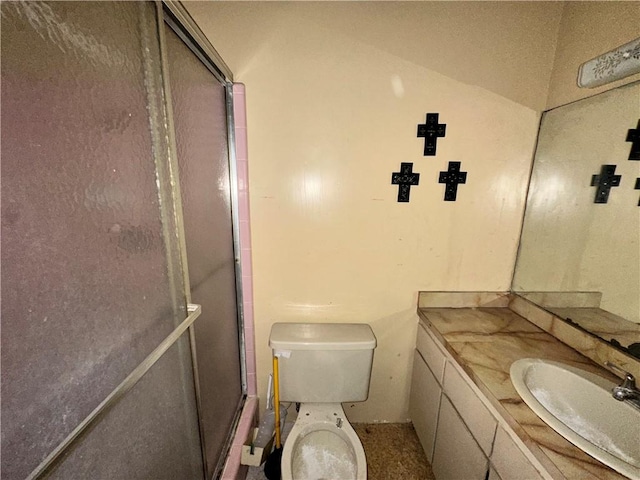 bathroom with vanity, toilet, and a shower with door