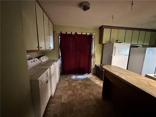 kitchen featuring washer and clothes dryer and white fridge