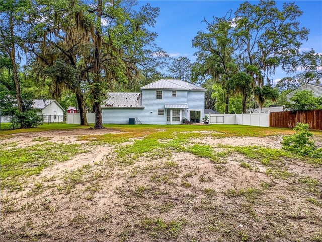416 S Deals Cir, Woodbine, GA 31569 - rear view of house featuring metal roof and fence