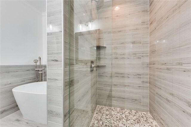 416 S Deals Cir, Woodbine, GA 31569 - full bath featuring a shower stall, tile walls, a freestanding tub, and ornamental molding