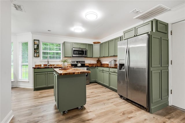 416 S Deals Cir, Woodbine, GA 31569 - kitchen with green cabinetry, wood counters, appliances with stainless steel finishes, crown molding, and a kitchen island