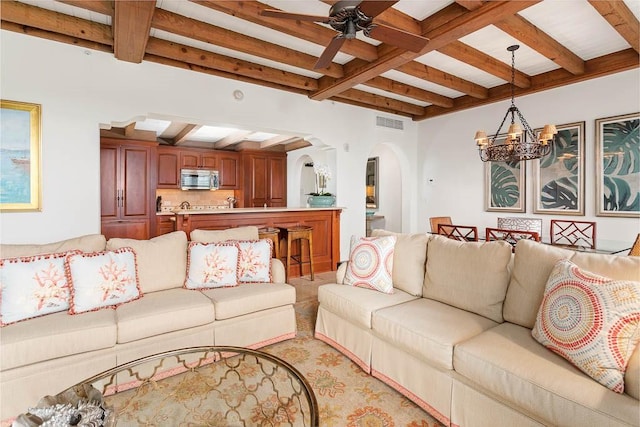 living room with beam ceiling and ceiling fan with notable chandelier