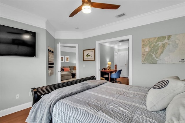 bedroom featuring visible vents, ornamental molding, a ceiling fan, wood finished floors, and baseboards