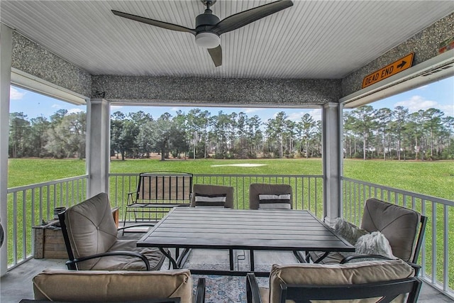 sunroom / solarium featuring plenty of natural light and a ceiling fan