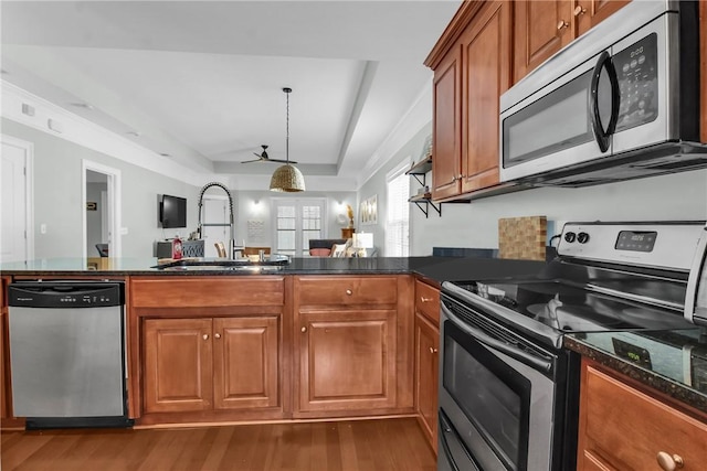 kitchen featuring appliances with stainless steel finishes, a sink, and brown cabinets