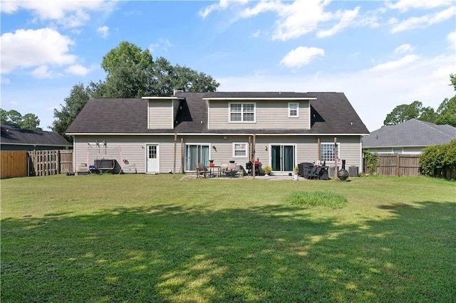 rear view of house with a lawn and central AC