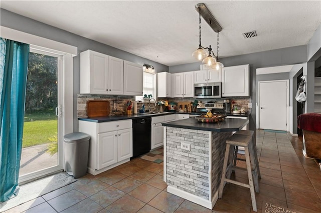 kitchen with white cabinets, backsplash, and stainless steel appliances