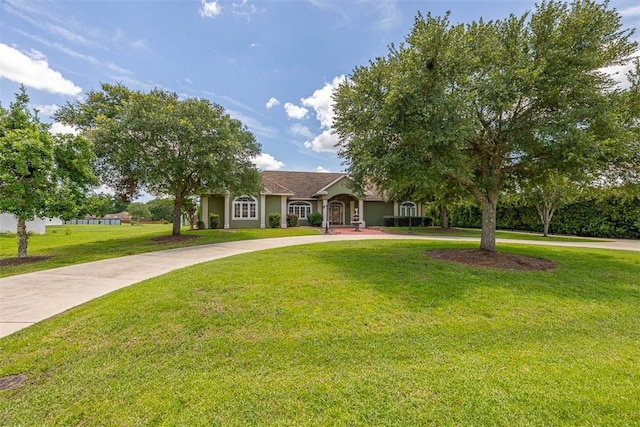 110 Rachel Way, Brunswick, GA 31523 - view of front of property with stucco siding, a front lawn, and curved driveway
