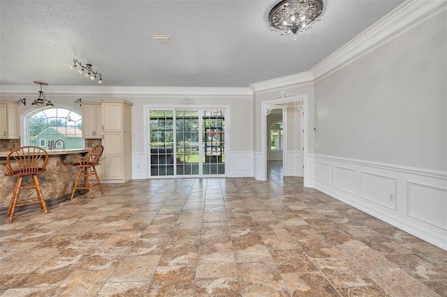 110 Rachel Way, Brunswick, GA 31523 - dining area featuring healthy amount of natural light, crown molding, a decorative wall, a textured ceiling, and wainscoting