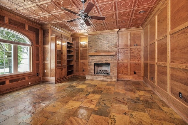 110 Rachel Way, Brunswick, GA 31523 - unfurnished living room with wood walls, a ceiling fan, a brick fireplace, and an ornate ceiling