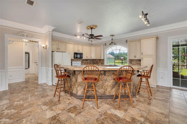 110 Rachel Way, Brunswick, GA 31523 - kitchen with white appliances, cream cabinetry, ornamental molding, a decorative wall, and ceiling fan