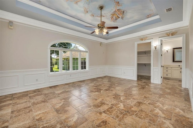 110 Rachel Way, Brunswick, GA 31523 - unfurnished room with a ceiling fan, light stone finish floors, a decorative wall, a wainscoted wall, and a tray ceiling