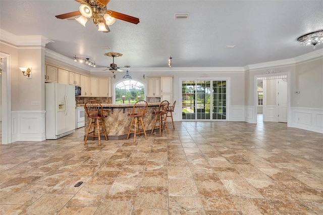 110 Rachel Way, Brunswick, GA 31523 - kitchen with white refrigerator with ice dispenser, a decorative wall, cream cabinets, ornamental molding, and range