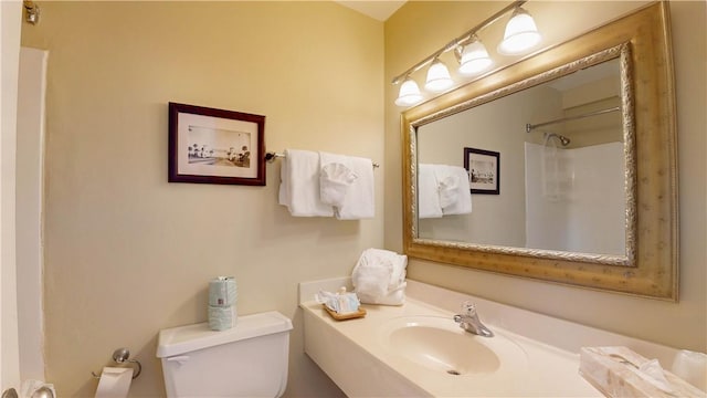 bathroom with walk in shower, sink, and toilet