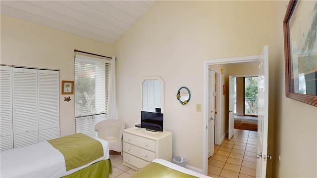 bedroom featuring a closet, lofted ceiling, and light tile patterned flooring