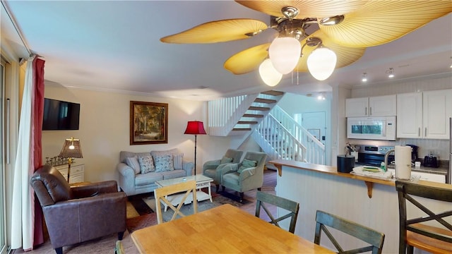 living room featuring crown molding and ceiling fan