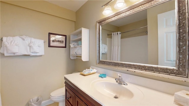 bathroom with vanity, curtained shower, and toilet