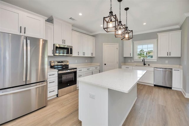 117 Rachel Way, Brunswick, GA 31523 - kitchen with appliances with stainless steel finishes, crown molding, light wood-type flooring, white cabinetry, and a center island