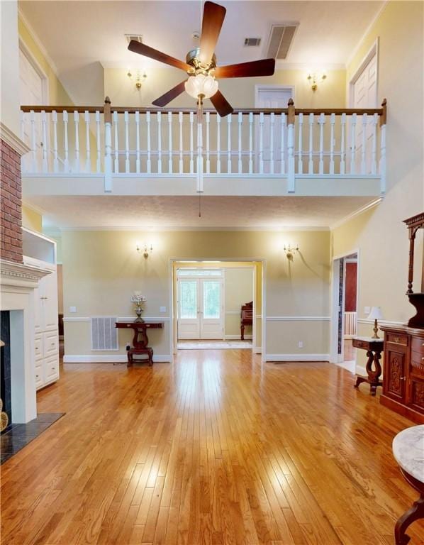 1457 N River Oaks Dr, Blackshear, GA 31516 - living room featuring a high ceiling, a fireplace with flush hearth, hardwood / wood-style flooring, a ceiling fan, and crown molding