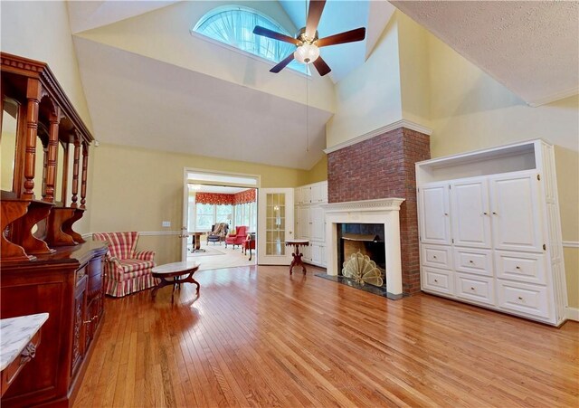 1457 N River Oaks Dr, Blackshear, GA 31516 - living room featuring a ceiling fan, high vaulted ceiling, light wood-style flooring, and a brick fireplace