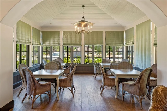 sunroom / solarium with wood ceiling, a healthy amount of sunlight, and an inviting chandelier