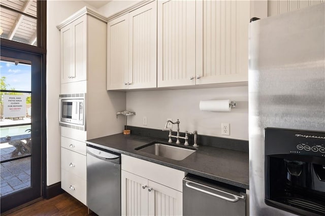 kitchen with white cabinets, appliances with stainless steel finishes, dark wood-type flooring, and sink