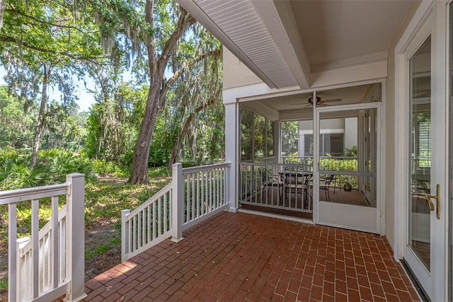 view of patio / terrace featuring ceiling fan and a sunroom