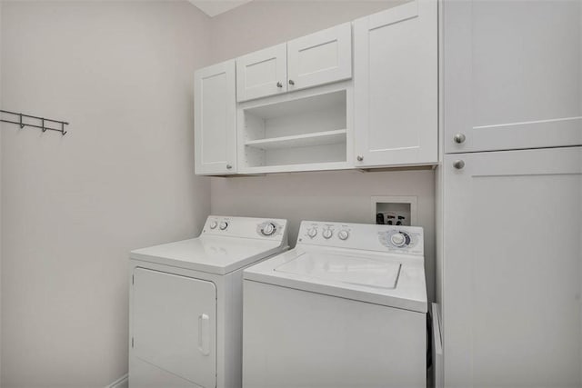 washroom featuring cabinet space and washer and clothes dryer