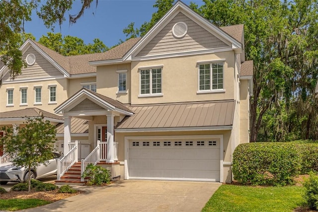 view of front of house featuring a standing seam roof, stucco siding, driveway, and a garage
