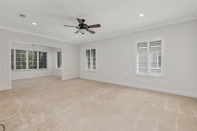 unfurnished room featuring crown molding, ceiling fan, light carpet, baseboards, and visible vents