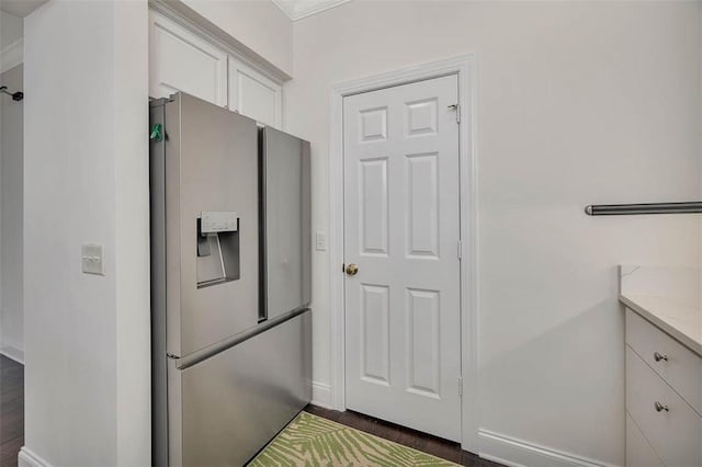 kitchen featuring white cabinets, baseboards, and stainless steel fridge