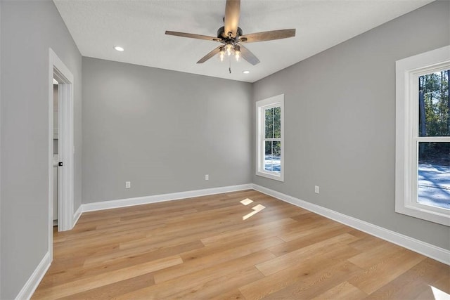 unfurnished room with ceiling fan, light hardwood / wood-style flooring, a healthy amount of sunlight, and a textured ceiling