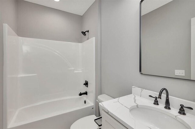 full bathroom featuring washtub / shower combination, vanity, and toilet