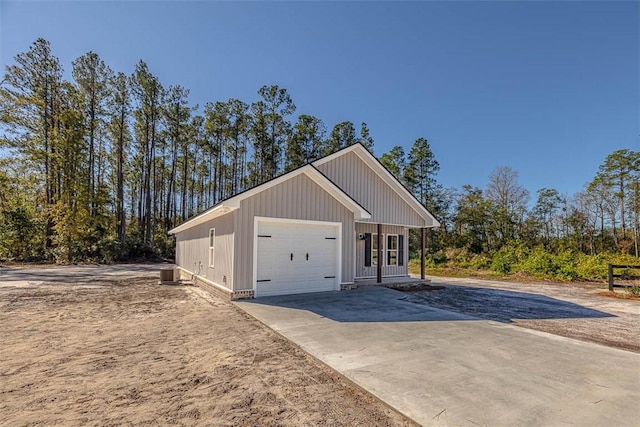 exterior space with covered porch, a garage, and central air condition unit