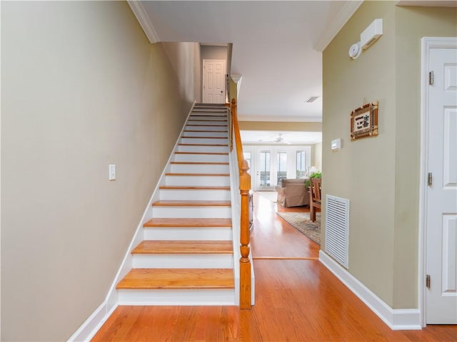 1106 Plantation Point Dr, Saint Simons Island, GA 31522 - staircase with ornamental molding, wood finished floors, baseboards, and a ceiling fan