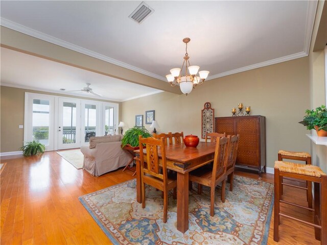 1106 Plantation Point Dr, Saint Simons Island, GA 31522 - dining space featuring a chandelier, crown molding, light wood-style floors, baseboards, and a ceiling fan