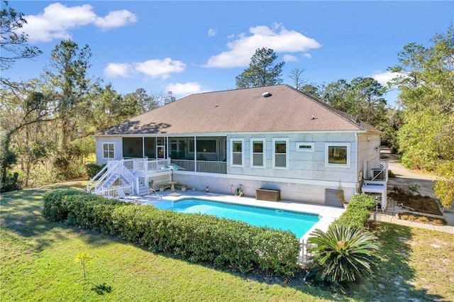 rear view of house with a sunroom and a lawn