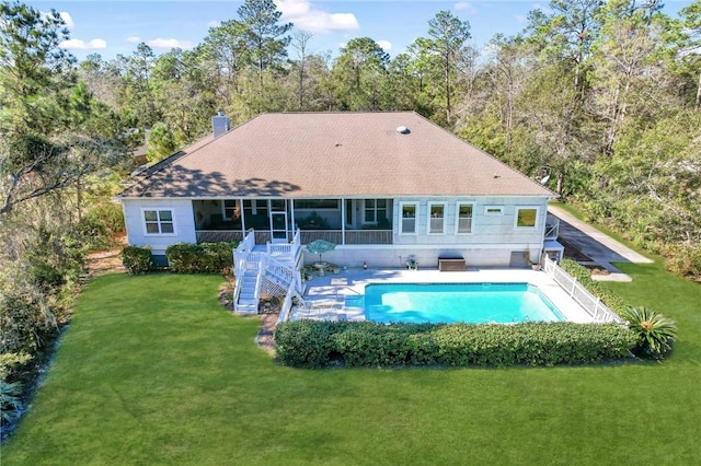 back of house featuring a yard and a sunroom