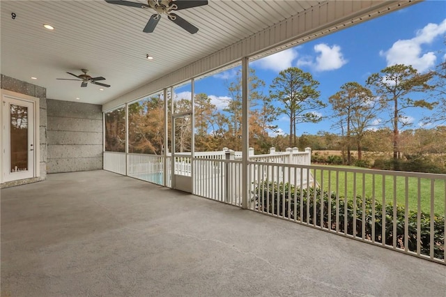 unfurnished sunroom with ceiling fan