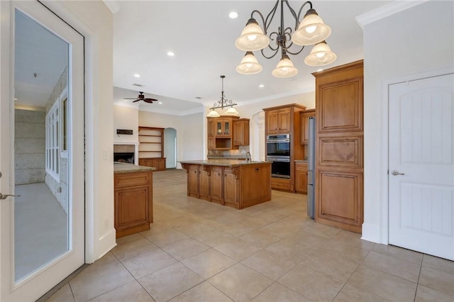 kitchen featuring stainless steel double oven, ornamental molding, a center island, and hanging light fixtures