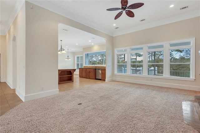 unfurnished living room with crown molding, sink, a healthy amount of sunlight, and ceiling fan with notable chandelier