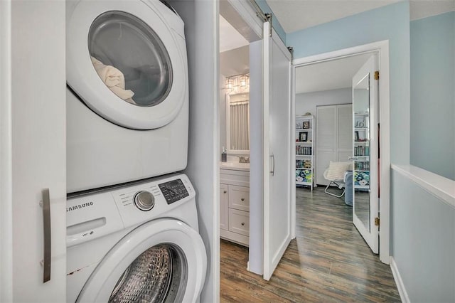 1000 Mallery Street Ext Unit G62, Saint Simons Island, GA 31522 - laundry area featuring stacked washing machine and dryer, wood finished floors, baseboards, a sink, and a barn door